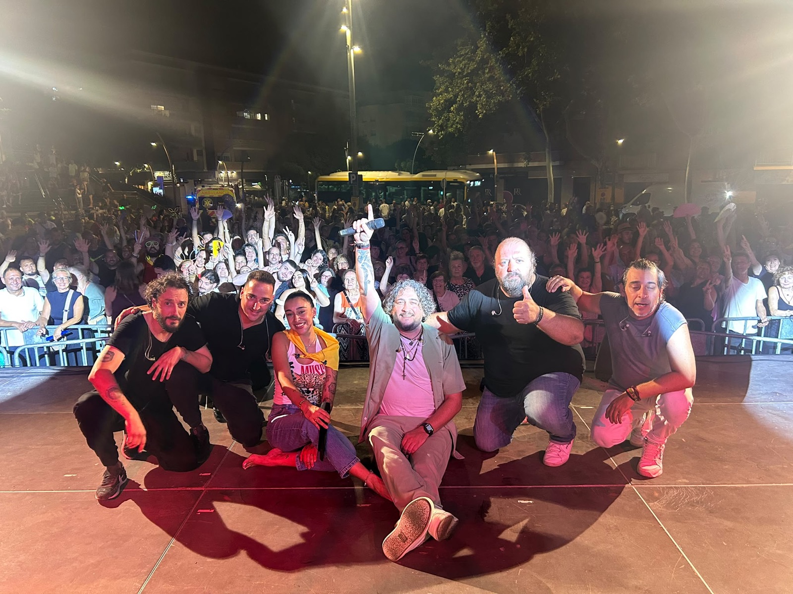 Banda de Por Camela con el público al completo en un concierto de noche en la calle